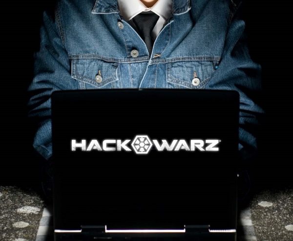 Person in a denim jacket using a laptop with the screen displaying "HACK WARZ" in bold white text.